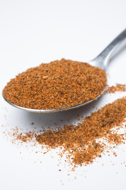 Fire & Smoke Society F&S | Chica Licka Bam Bam Bird Rub 10.7 oz, a metal spoon filled with spicy chicken rub seasoning on a white background.