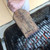 Great Scrape The Great Scrape Woody Paddle Grill Scraper, a wooden paddle grill scraper used for cleaning a barbecue grill, held above hot charcoal on the grill.