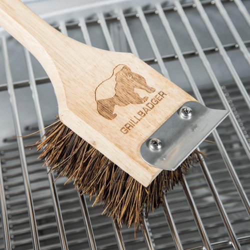 Grill Badger Brush, wooden handle with a logo of a badger engraved, metal scraper attached, used for cleaning grills.