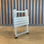 PK Grills Aluminum Compact Foldable Table, a portable aluminum table in folded position with a modern design, lightweight construction, and black feet, suitable for outdoor or camping use.