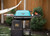 PK Grills PK300AF Start Cookin' Bundle - Teal, outdoor barbecue grill with teal lid, side tray with accessories, black backpack, and a hammock in the background.