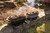 PK Grills PKGO with FlipKit, portable outdoor mini grills with sausages, vegetables, and smoke on grill grates for outdoor cooking and camping.
