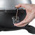 PK Grills PKGO with FlipKit, close-up of a hand attaching the FlipKit to the main grill body with a screwdriver.